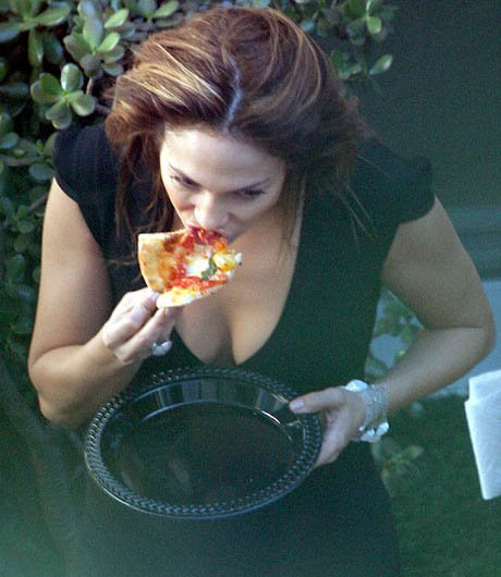 ДжейЛо с вожделением вгрызалась в кусок пиццы, совершенно позабыв о диете.