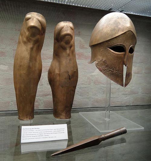 Спартанские поножи, наконечник копья и коринфский шлем воина по имени Денда, 500-490 гг до н.э. wikimedia 