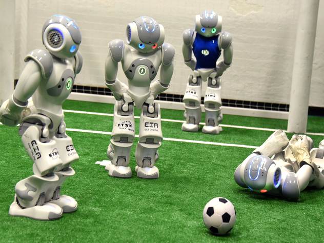 Роботы играют футбол.