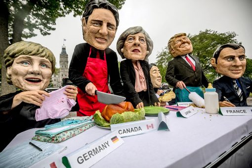 Активисты в масках лидеров G7 выступают в поддержку женщин по всему миру. Они изображают, как Дональд Трамп, Эмманюэль Макрон, Ангела Меркель и другие лидеры выполняют «обычную женскую работу» — нянчат детей и готовят, одновременно пытаясь управлять каждый своей страной