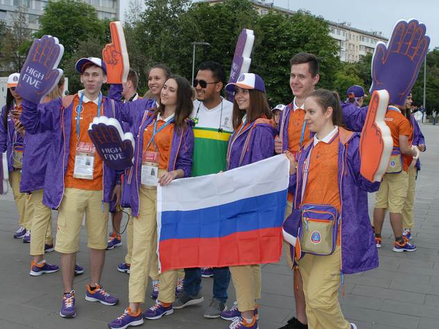 Российские волонтеры фотографируются с иностранными болельщиками.