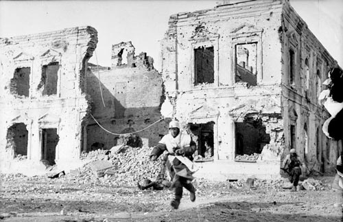 Немецкие солдаты в зимних маскхалатах пересекают бегом открытую местность, г. Холм. Январь 1942 г. Источник: wikipedia.org