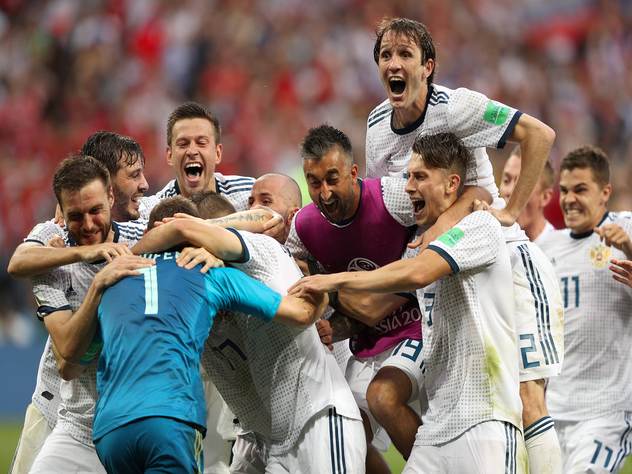 Российские футболисты обнимают вратаря Игоря Акинфеева после победной серии пенальти.