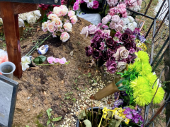 Перевернутые вверх стеблями цветы на могиле Евгения Осина