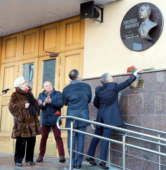 Шатилова и Киселев наблюдали, как Евгений Ревенко (справа) возложил к мемориальной доске букет