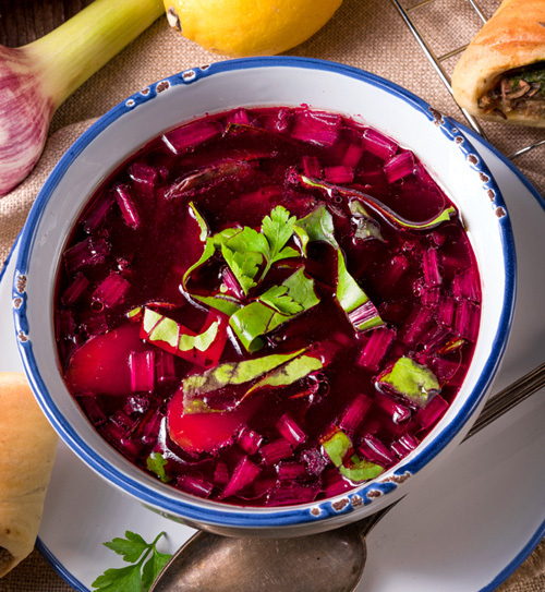 Свекольник История: почему-то считается, что этот холодный суп пришел в Россию из Белоруссии, Литвы и Польши в Средние века, хотя свекла, наоборот, проделала обратный путь. Наши предки выращивали корнеплод еще в Х веке, и лишь через пару столетий он стал привычным для соседей. Свекольник - изначально суп для бедняков, иногда им даже свеклы не доставалось, только ее отвар плюс зеленый лук и хлеб. Классического рецепта не существует, в каждом регионе свои нюансы. База такая: вареная или тушеная свекла и ее ботва, огурцы, отварные яйца. Все мелко режется или трется, заливается охлажденным свекольным отваром, иногда пополам с квасом. Сметана и зелень - по желанию. Кто-то добавляет картофель (на Руси клали репу), мясо, птицу, рыбу или раков. Плюсы: много овощей - значит, масса витаминов, низкокалорийно - подойдет худеющим (без картошки, конечно). Минусы: долго готовится, так как нужно отварить свеклу, затем остудить отвар. Польза В свекле содержатся калий, железо, кальций, магний, витамины группы В, антиоксиданты. Пектиновые вещества помогают улучшить пищеварение, а бетаин - укрепить сосуды и снизить уровень холестерина. В корнеплоде высокое содержание йода, он обладает мочегонным и слабительным эффектом. Вред В свекле высокое содержание сахара, так что при диабете лучше воздержаться от нее. Не стоит увлекаться блюдами из свеклы и тем, у кого есть заболевания почек и мочевого пузыря. Имейте в виду, что вещества, содержащиеся в овоще, мешают усвоению кальция, так что он не рекомендован при остеопорозе. Кстати Гиппократ использовал листья свеклы для заживления ран и воспалений кожи. А древние римляне были уверены: свекла - афродизиак.